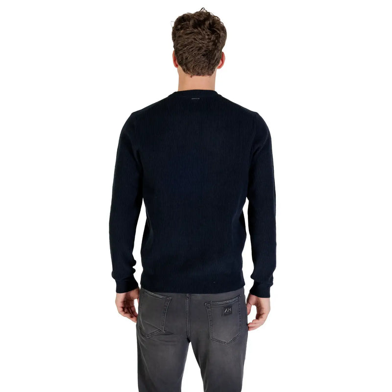 Navy blue crew neck sweater with ribbed cuffs and hem, likely made of cotton or a similar soft fabric.