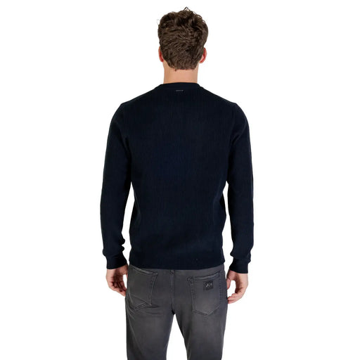 Navy blue crew neck sweater with ribbed cuffs and hem, likely made of cotton or a similar soft fabric.