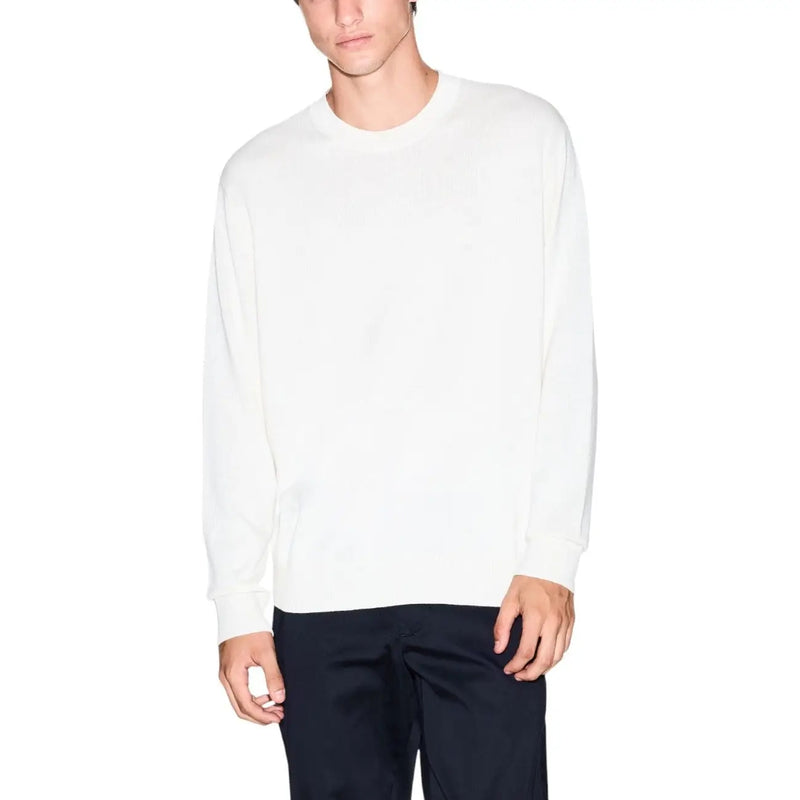 White crew neck sweater with long sleeves and ribbed cuffs, likely made of cotton or a similar soft material.