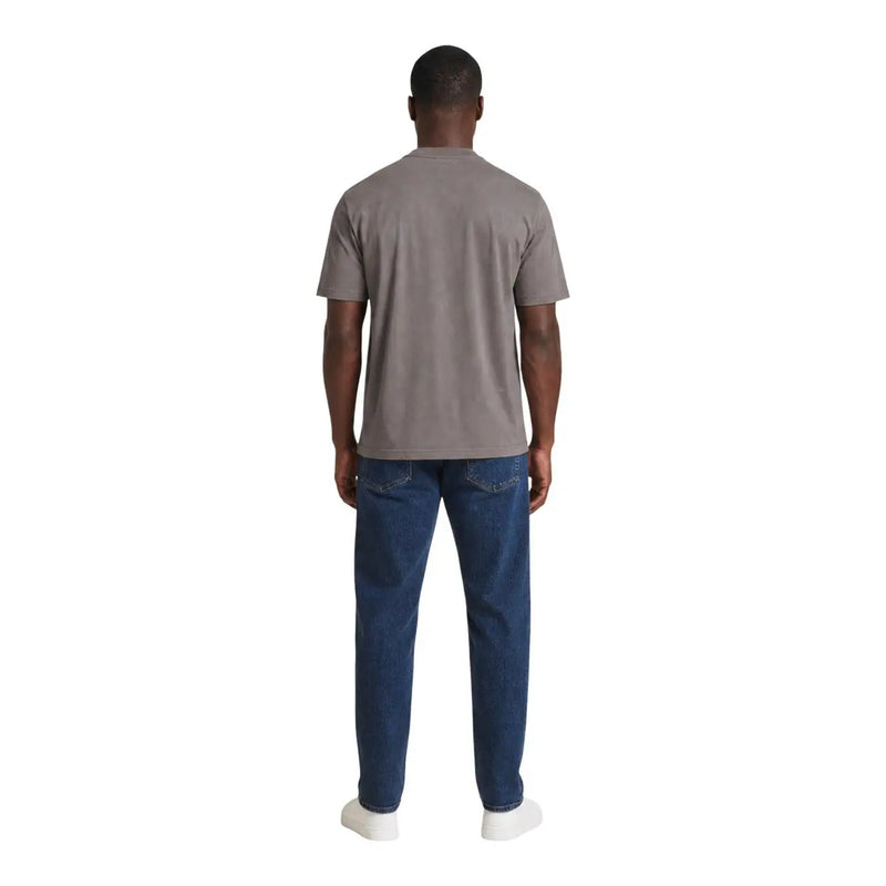 Ein Mann, der einen Armani Exchange Braunes Baumwoll-T-Shirt für Herren kombiniert mit dunkelblauen Jeans