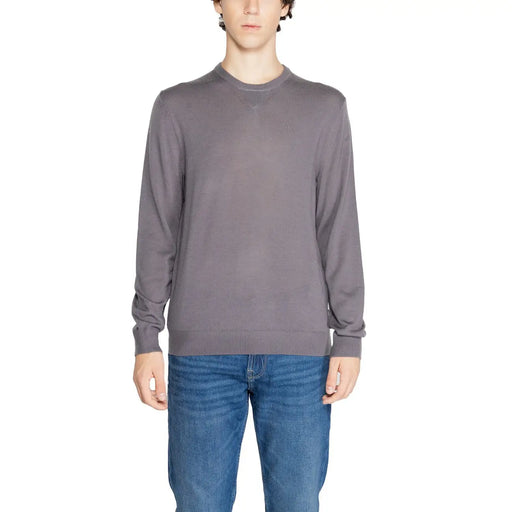 Man wearing Armani Exchange men’s blue wool-blend sweater and blue jeans