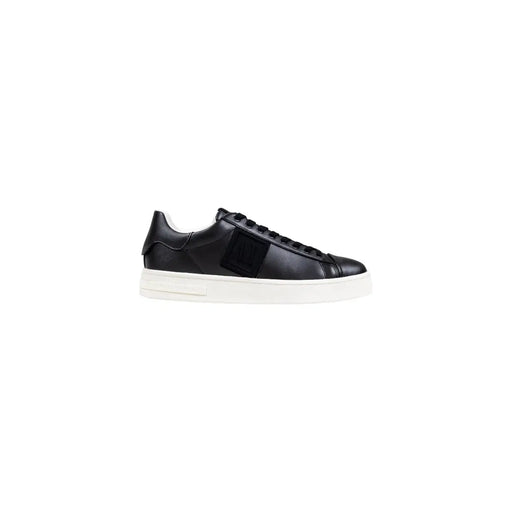 Black leather low-top sneaker with white sole and strap detail.