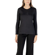 Woman wearing a black long-sleeved crew-neck top and black track pants, showcasing Armani Exchange T-shirt