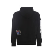 Schwarzer Kapuzenpullover mit kleinem rechteckigem Fotoaufnäher auf der linken Brust und weißem Grafikdesign auf dem rechten Ärmel