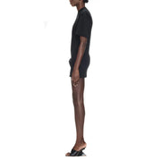 Black short-sleeved mini dress with high neckline and subtle side seam detail paired with sculptural heels and knotted detail