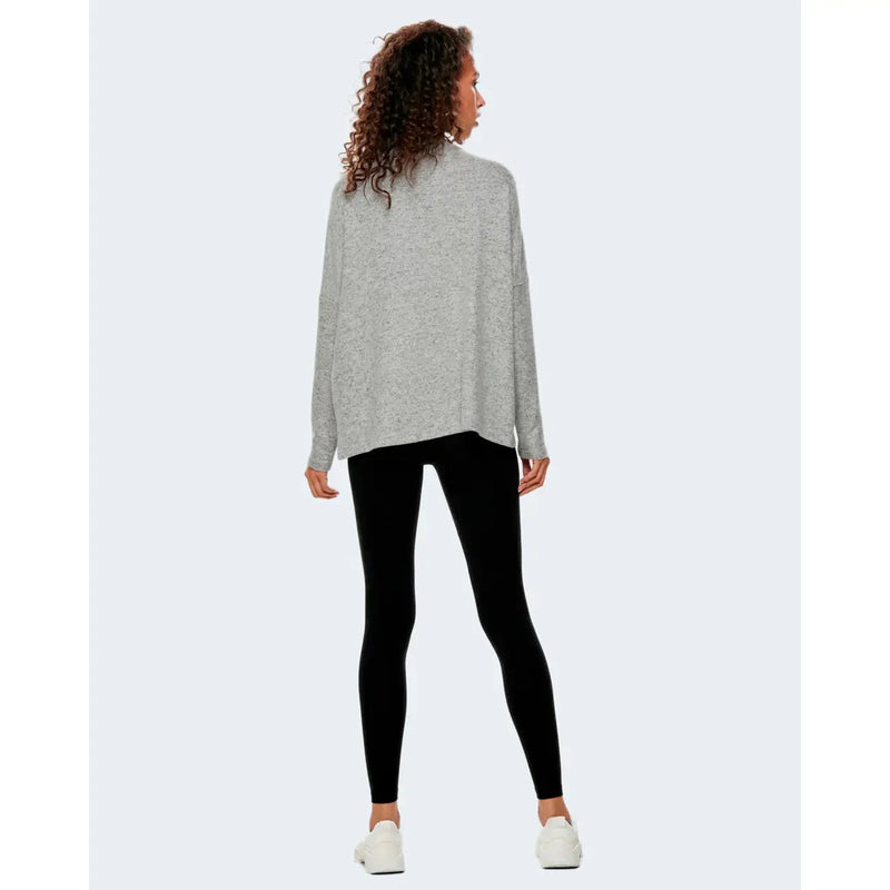 A soft heather gray oversized knit sweater with long sleeves paired with black women’s leggings for fall and winter