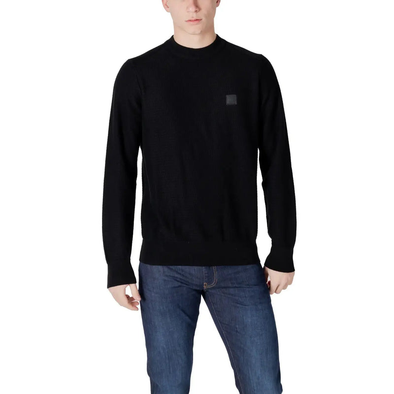 Man wearing a black crewneck sweater from Boss Men Green Long Slip-On Knit Sweater collection