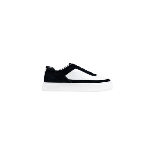 Black and white platform sneaker with velcro strap, textured upper material.