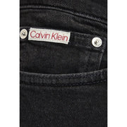Schwarze, schmal geschnittene Baumwoll-Denim-Jeans für Herren mit weißem Calvin Klein Etikett mit roter Schrift und silbernen Nieten