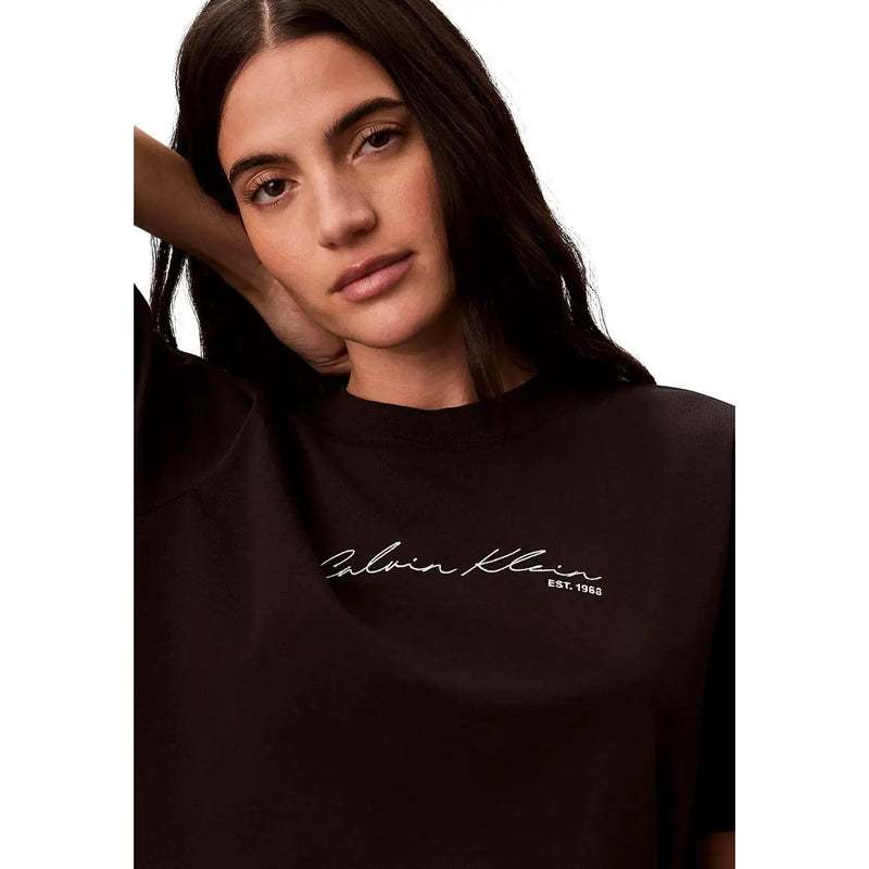 Schwarzer Rundhalsausschnitt aus Baumwolle Calvin Klein Jeans Damen-T-Shirt mit weißem, geschwungenem Logo und „est“-Detail auf der Vorderseite
