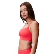 Leuchtend korallenfarbene Calvin Klein Jeans, orangefarbenes Bralette mit dünnen Trägern und elegantem, modernem Design für den Strand