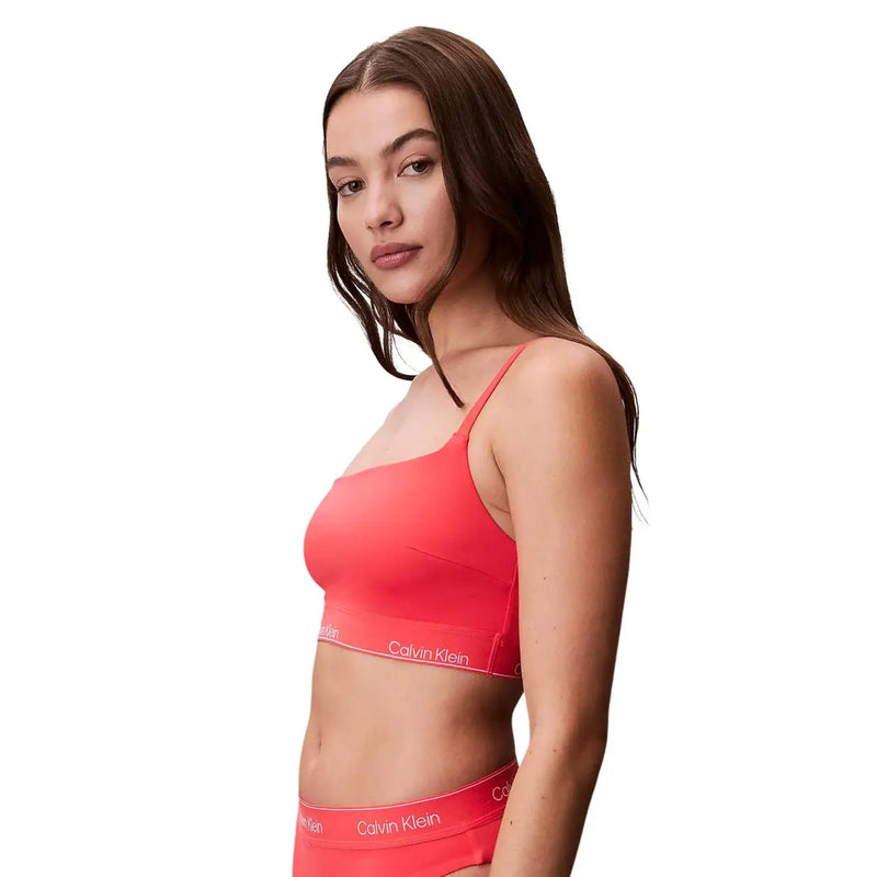 Leuchtend korallenfarbene Calvin Klein Jeans, orangefarbenes Bralette mit dünnen Trägern und elegantem, modernem Design für den Strand