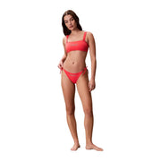Ein leuchtend korallenfarbenes Calvin Klein Jeans Damen-Bikini-Set mit orangefarbenen Streifen und Bandeau-Oberteil top und dazu passende Unterteile mit seitlichen Bindebändern