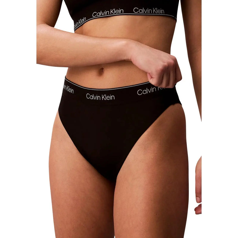 Schwarze, hochgeschnittene Nylon-Slips von Calvin Klein mit weißem Markenlogo am Bund für Damen, geeignet für den Strand.