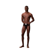 Schwarzer Calvin Klein Herren-Hüftslip aus Baumwolle mit weißem Etikett am Bund, das auf der Vorderseite sichtbar ist
