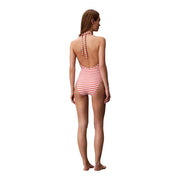 Eine Frau trägt eine Calvin Klein Damen-Badeanzug aus orange gestreiftem Nylon, einteilig, mit rot-weißen Neckholder-Trägern