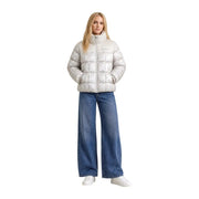 Eine Frau trägt eine weiße Steppjacke mit silbernen Mustern. Columbia Damen-Blazer aus beigefarbenem Polyester