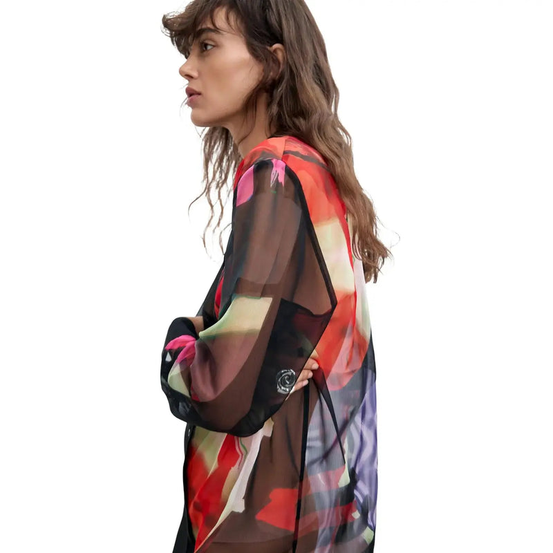 Schwarzes langes Damenkleid von Desigual mit transparenter, langärmeliger Bluse und einem auffälligen abstrakten Muster in Rot, Rosa und Lila.