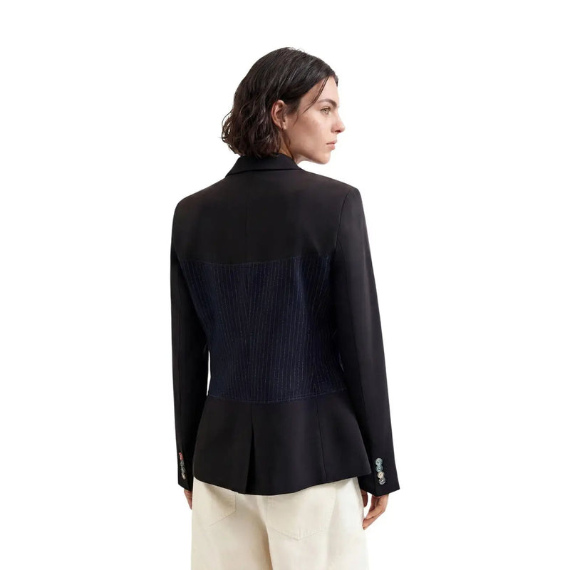 Rückansicht eines blauen, geometrischen Damenblazers von Desigual aus Viskosemischung mit marineblauem Falteneinsatz und dekorativen Manschettenknöpfen.