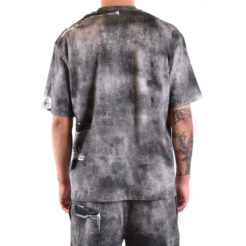 Diesel Schwarzes Herren-T-Shirt aus Baumwolle mit grau-schwarzem Batikmuster und sichtbaren Used-Effekten mit Rissen an Ärmeln, Rücken und Saum.