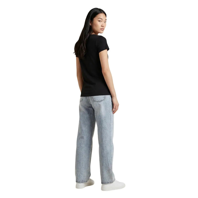 Hellblaue Jeans mit lässigem, geradem Bein, kombiniert mit einem schwarzen Kurzarm-T-Shirt von ea7 für Damen aus Baumwolle mit Rundhalsausschnitt.