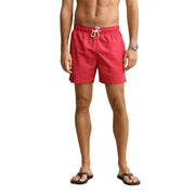 Gant men swimwear light blue polyamide board shorts shown with red swim trunks featuring a white drawstring waistband