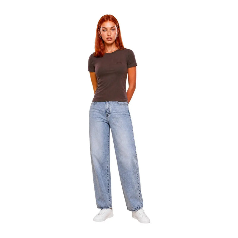Eine Frau trägt ein dunkelgraues Guess Active Braunes, kurzes Chara-T-Shirt aus Viskose mit hellen, weit geschnittenen Jeans.