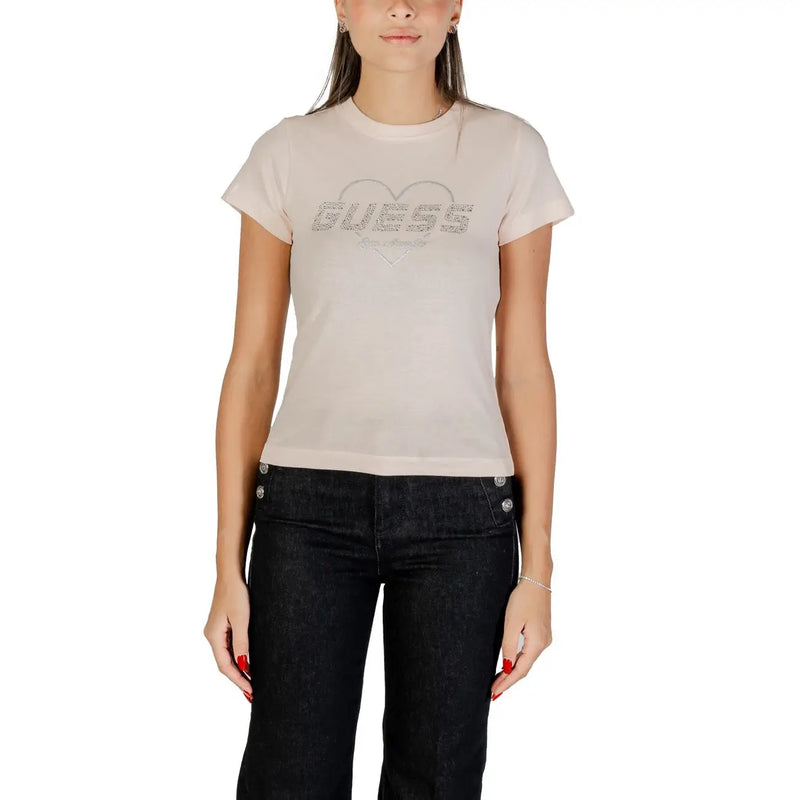Woman wearing light pink Guess T-shirt with heart design and dark denim pants