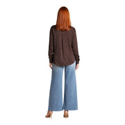 Eine Frau trägt eine Guess Damenbluse aus braunem Polyester mit klassischen langen Ärmeln und kleinen weißen Punkten.