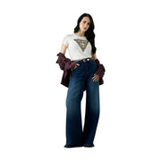 Frau trägt dunkelblaue, weite Jeans mit weißem Guess Damen-Baumwoll-T-Shirt mit Schlangenmuster, Dreiecksausschnitt und Rundhalsausschnitt sowie bordeauxrote Jacke