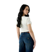 Eine Frau, die ein weißes Baumwollkleid trägt Guess Damen-T-Shirt mit Schlangenmotiv und Rundhalsausschnitt, von der Rückseite gesehen