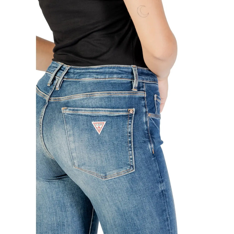 Back side of guess women’s blue denim jeans with a worn-out effect and red white triangular logo patch on pocket