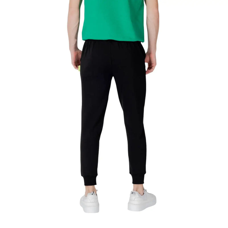 Icon Schwarze, gestreifte Herren-Jogginghose aus Baumwollmischgewebe mit elastischen Bündchen und dezentem gelbem Etikett an der Seitennaht.