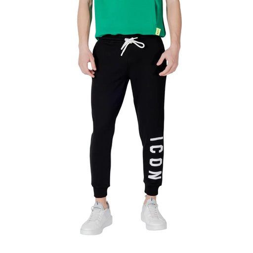 Icon Schwarze, gestreifte Herren-Freizeithose aus Baumwollmischgewebe mit schwarzem Jogginghosen-Schnitt, weißem Kordelzug und vertikalen Streifen. icon Beschriftung