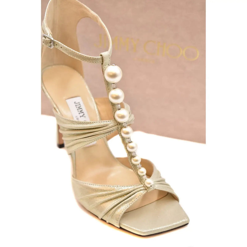 Jimmy Choo Damen-Ledersandale in Beige mit goldfarbenem Metallic-Finish, Stilettoabsatz, offener Zehenpartie und weißen Perlenverzierungen