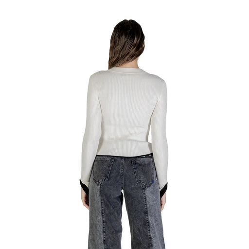 Woman wearing Karl Lagerfeld white long round neck knitwear and dark gray wide-leg jeans