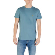 Man wearing a blue Lacoste Men short round neck T shirt and jeans