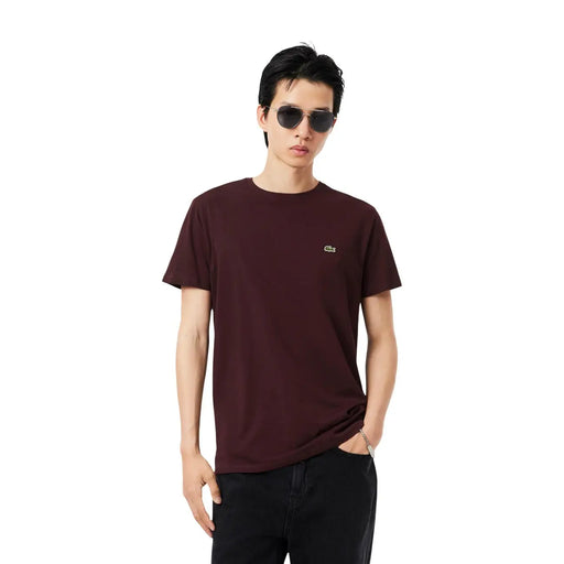 Ein bordeauxrotes, kurzärmeliges Baumwoll-Herrenhemd von Lacoste t-shirt mit einem gestickten Krokodillogo auf der linken Brust