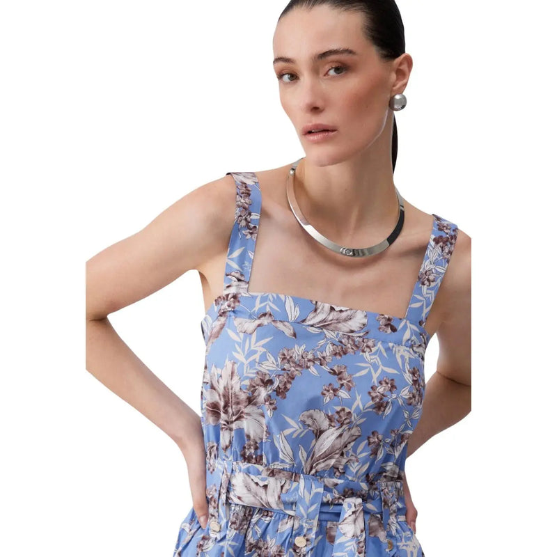 Eine Frau, die eine Liu Jo Ärmelloses, blaues Baumwollkleid mit Blumenmuster für Damen mit dünnen Trägern und passendem Taillengürtel