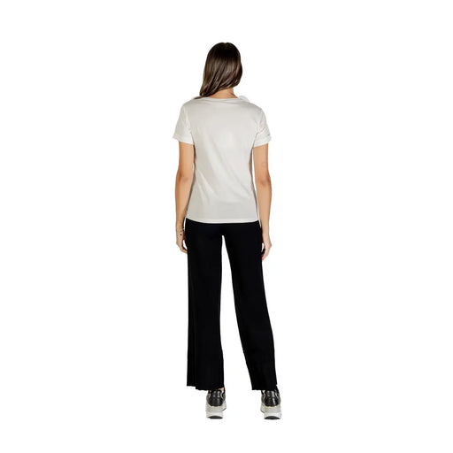 Light-colored short-sleeved cotton T-shirt with round neck paired with black wide-leg pants