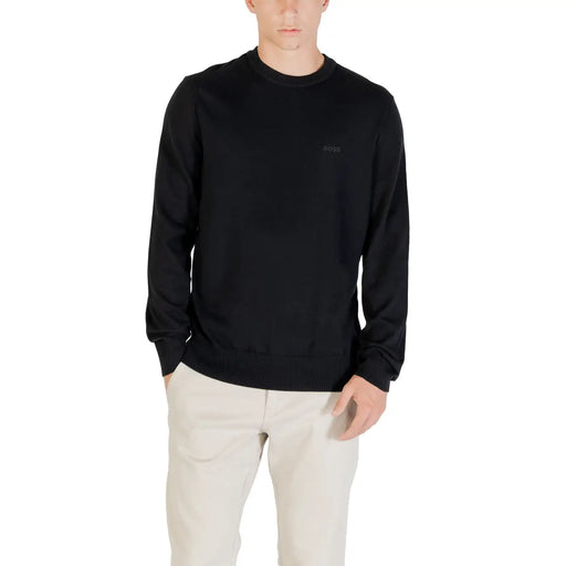 Man wearing a black long-sleeved shirt and light-colored pants showcasing casual style