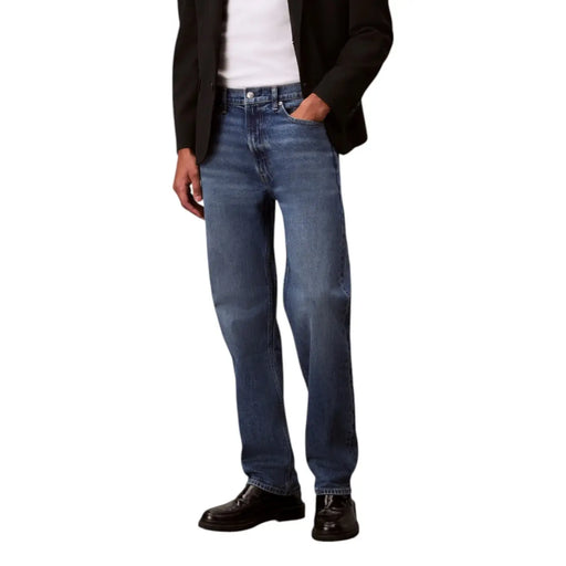 Man in black blazer and blue jeans modeling stylish casual wear in a fashion photo
