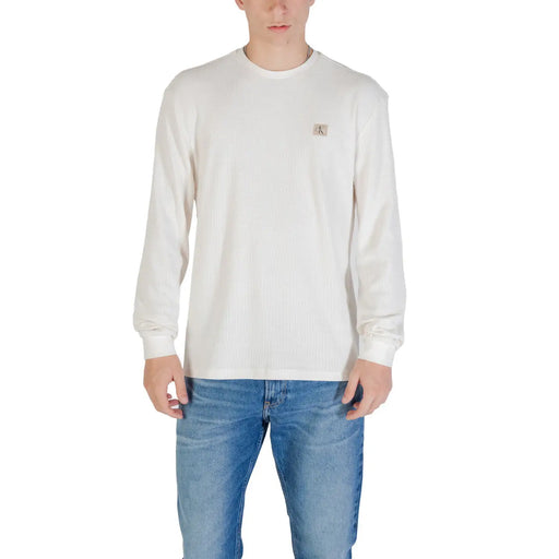 Man wearing an off-white long-sleeved shirt and blue jeans for the product Man in Long Sleeve Shirt and Blue Jeans