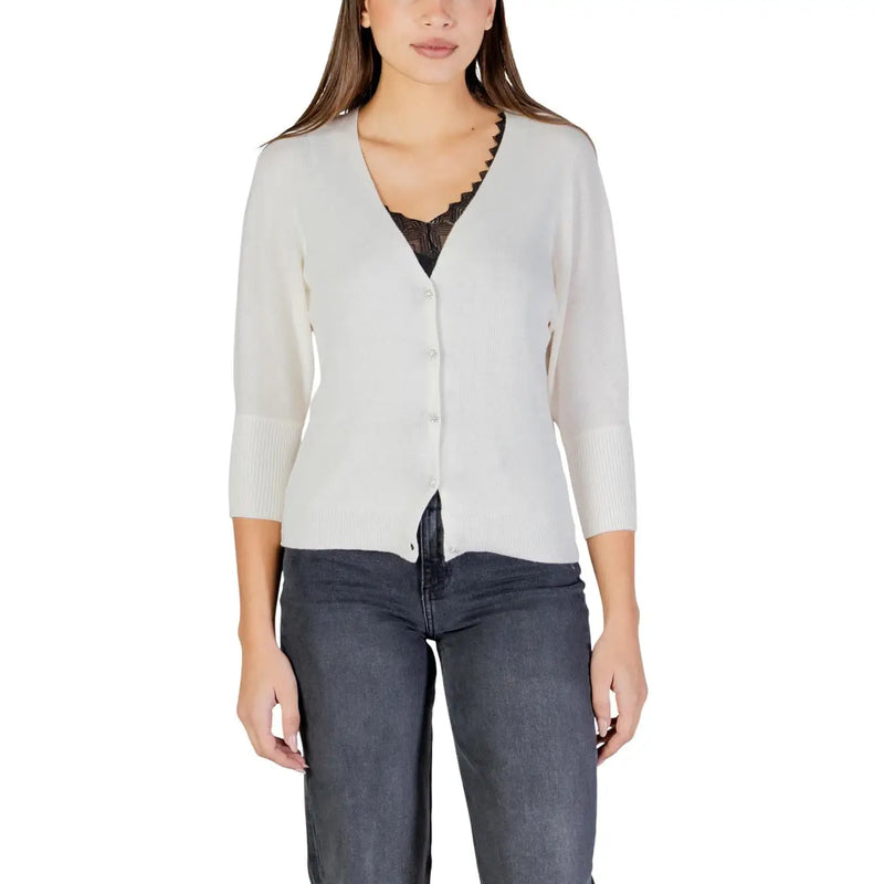Ein weicher, elfenbeinfarbener Strickstoff Morgan De Toi Beigefarbene Damen-Strickjacke mit Knöpfen, V-Ausschnitt und dezent gerippten Dreiviertelbündchen