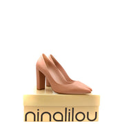 Ein Paar pinkfarbene Ninalilou-Pumps aus Leder mit Blockabsatz in Nude-Farbe und spitzer Zehenpartie, verpackt in einem Markenkarton.