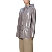 Ein eleganter, metallisch-grauer Regenmantel mit glänzendem Finish und schwarzen Knöpfen, kombiniert mit einer lila Polyester-Kapuzenjacke für Damen.