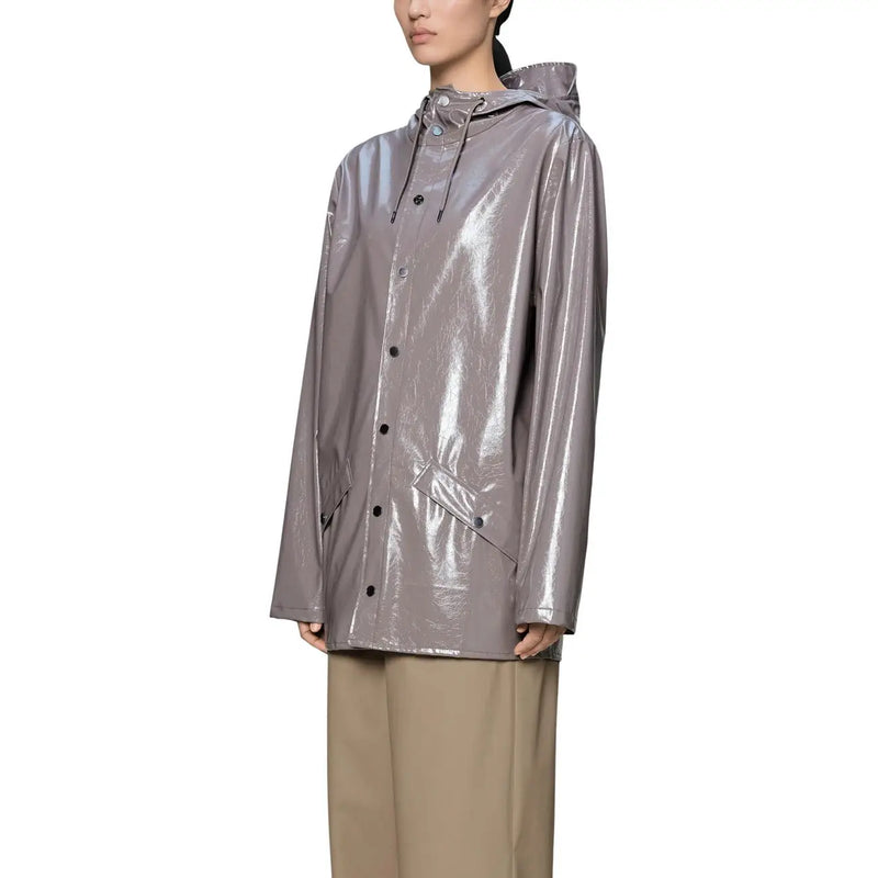 Ein eleganter, metallisch-grauer Regenmantel mit glänzendem Finish und schwarzen Knöpfen, kombiniert mit einer lila Polyester-Kapuzenjacke für Damen.