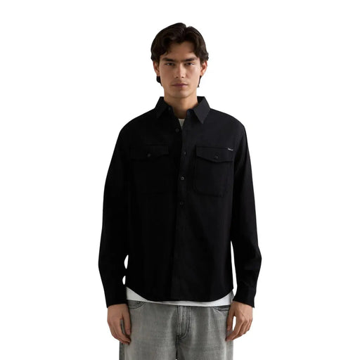 Schwarzes Herren-Jeanshemd von Replay aus Baumwolle mit langen Ärmeln, zwei Brusttaschen und dezentem Markenlogo auf der linken Brustseite.