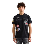 Grünes Herren-T-Shirt aus Baumwolle von Replay mit lockerer Passform, schwarzem Kurzarmdesign und farbenfrohen Tokyo-Room-Aufnähern auf der Brust.