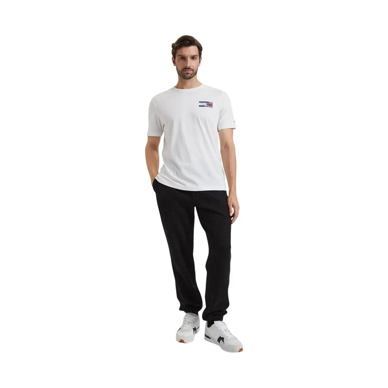 Weiß Tommy Hilfiger t-shirt mit einem kleinen rechteckigen Logo auf der Brust, kombiniert mit einer schwarzen Fleecehose aus Baumwollmischgewebe